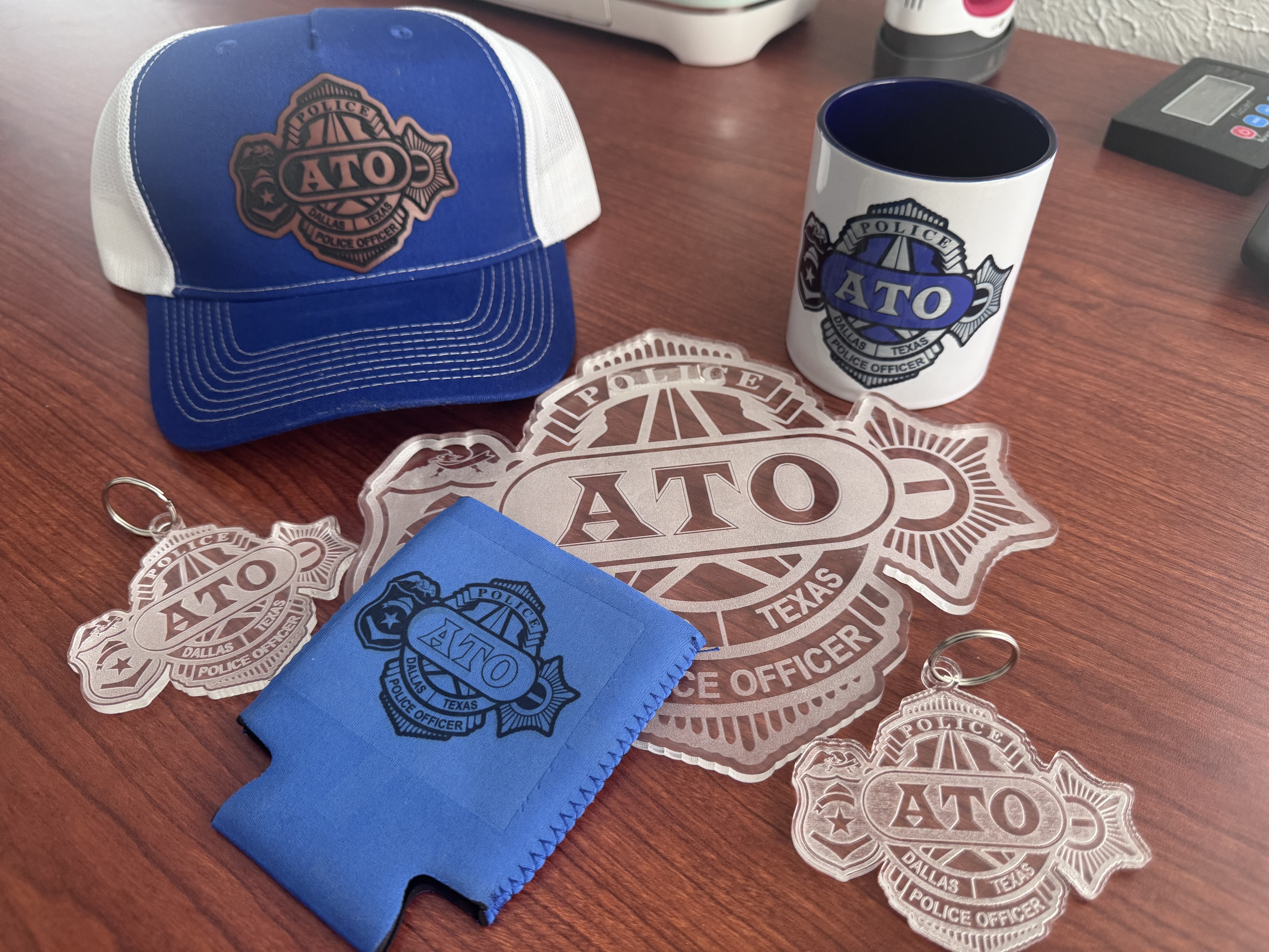 Branded merchandise spread — leather patch hat, patches, mug, and keychains